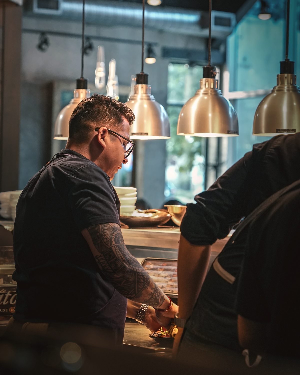 Guillermo Roque checking plates at the pass under the heat lamps during service
