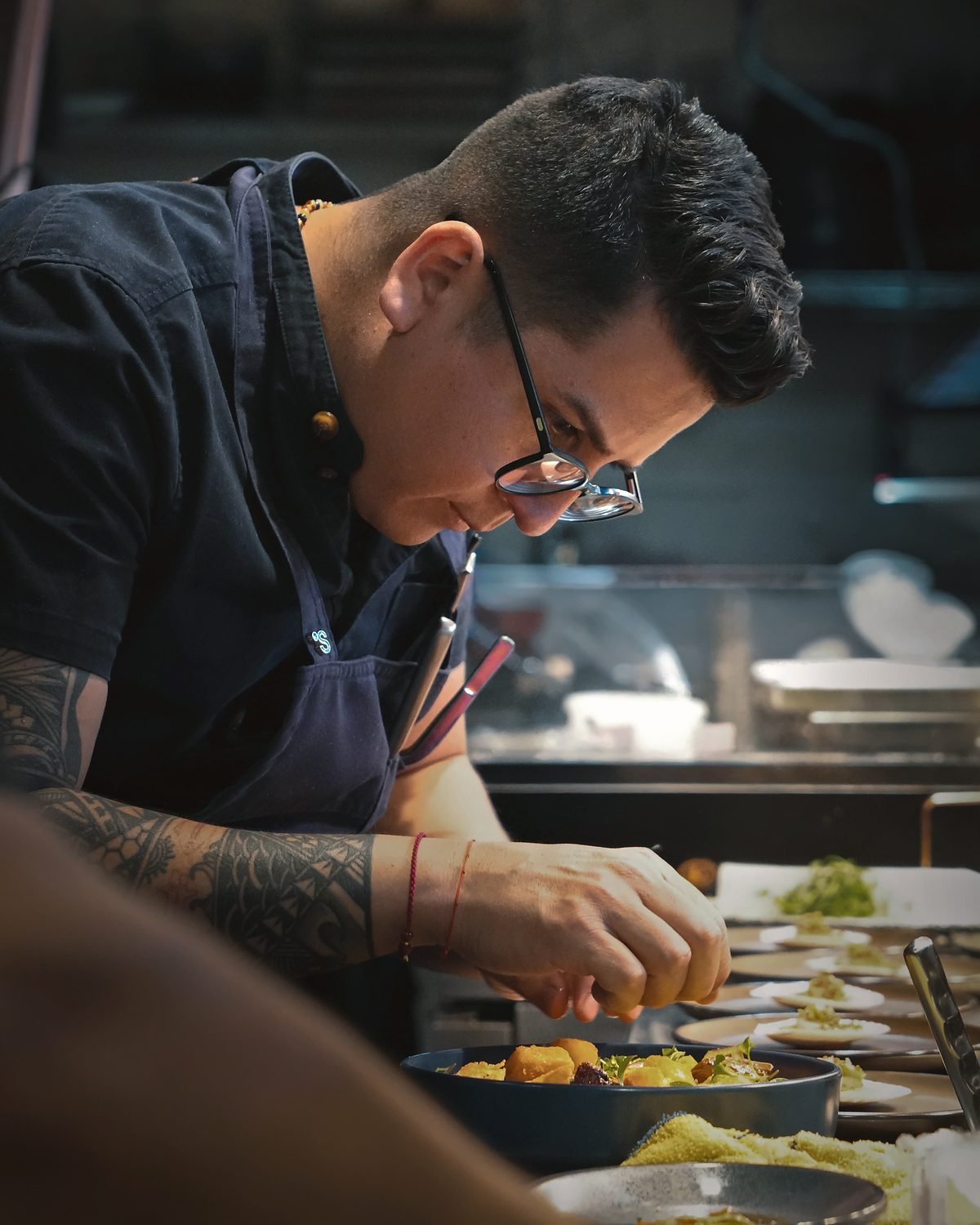 Guillermo Roque finishing a dish by hand at the kitchen counter