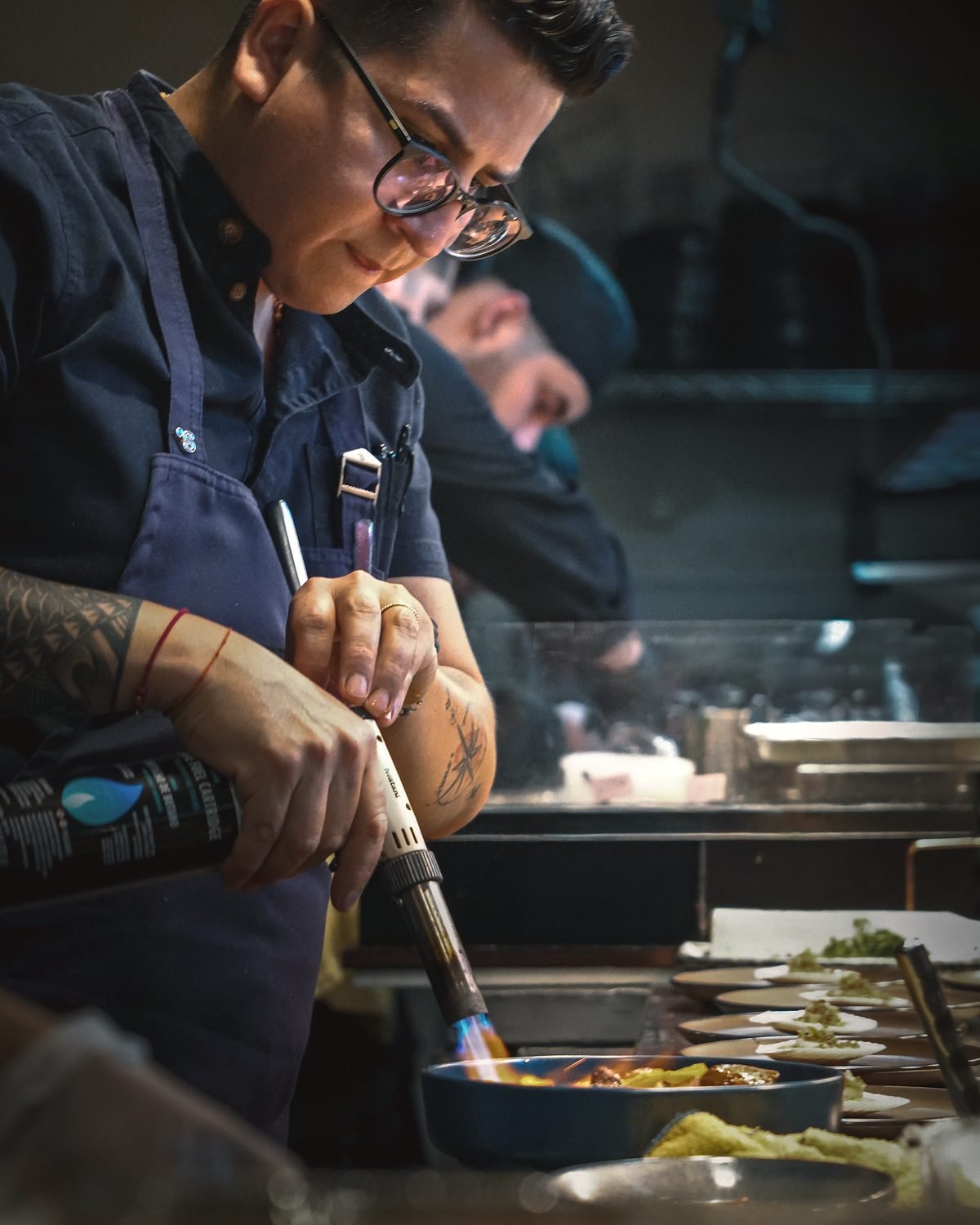 Guillermo Roque usando un soplete para terminar un plato durante el servicio