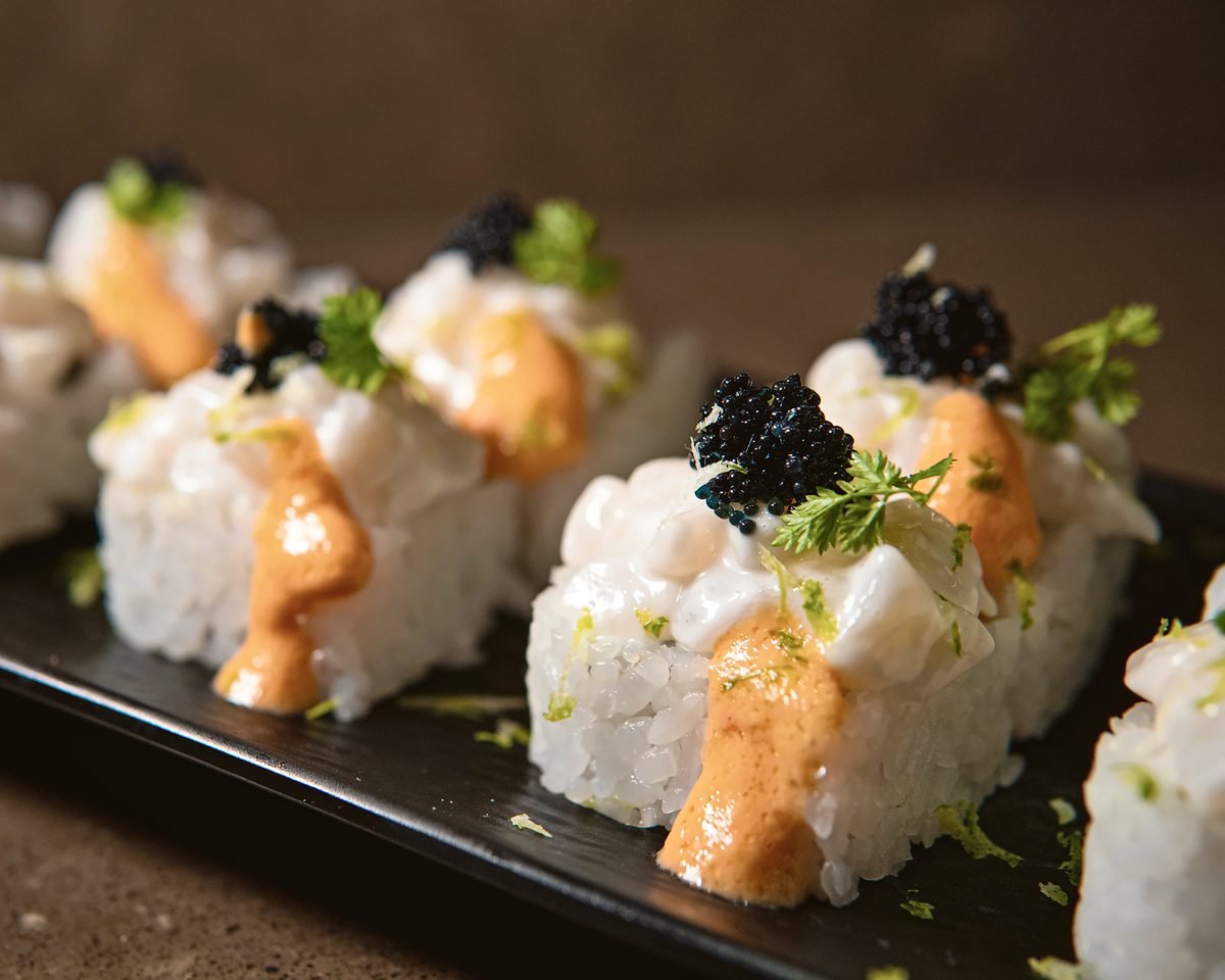 Una fila de piezas de maki idénticas con caviar, muestra de ejecución consistente